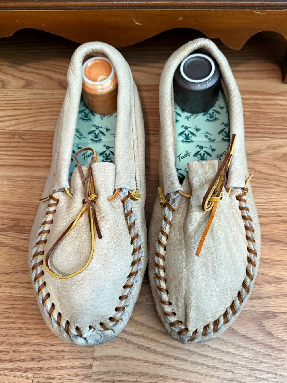 Taos brand genuine deerskin moccasins, featuring a light tan leather upper